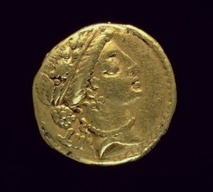 Aureus (anverso) acuñado por Julio César (110-44 a.C.) que representa una cabeza femenina a la derecha con una corona de roble y diadema